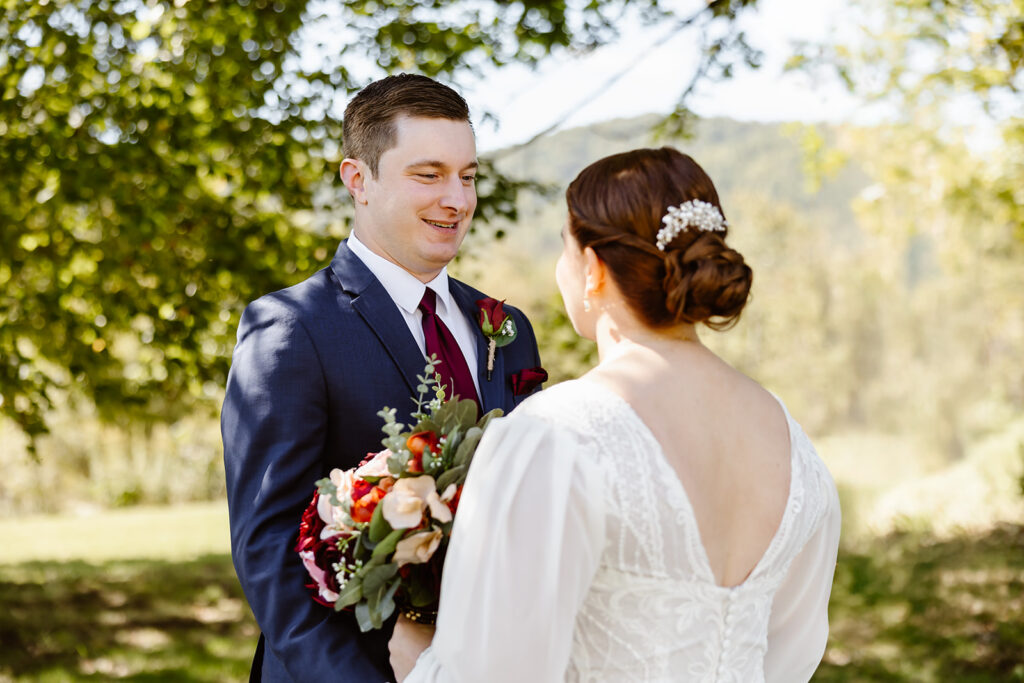 the wedding couple smiling at one another during their first look