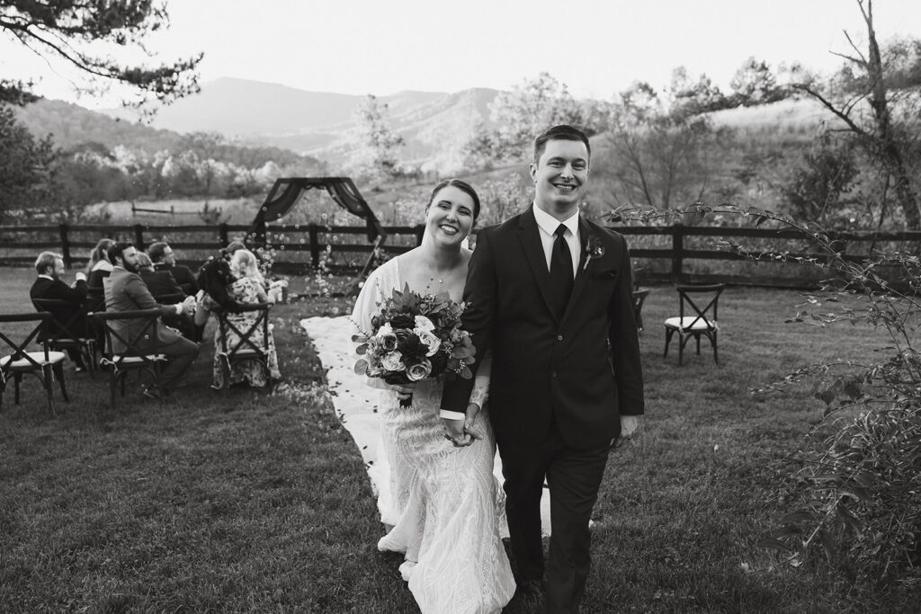 Black and white photo of wedding couple walking up the aisle after the wedding ceremony in Shenandoah National Park in Virginia.