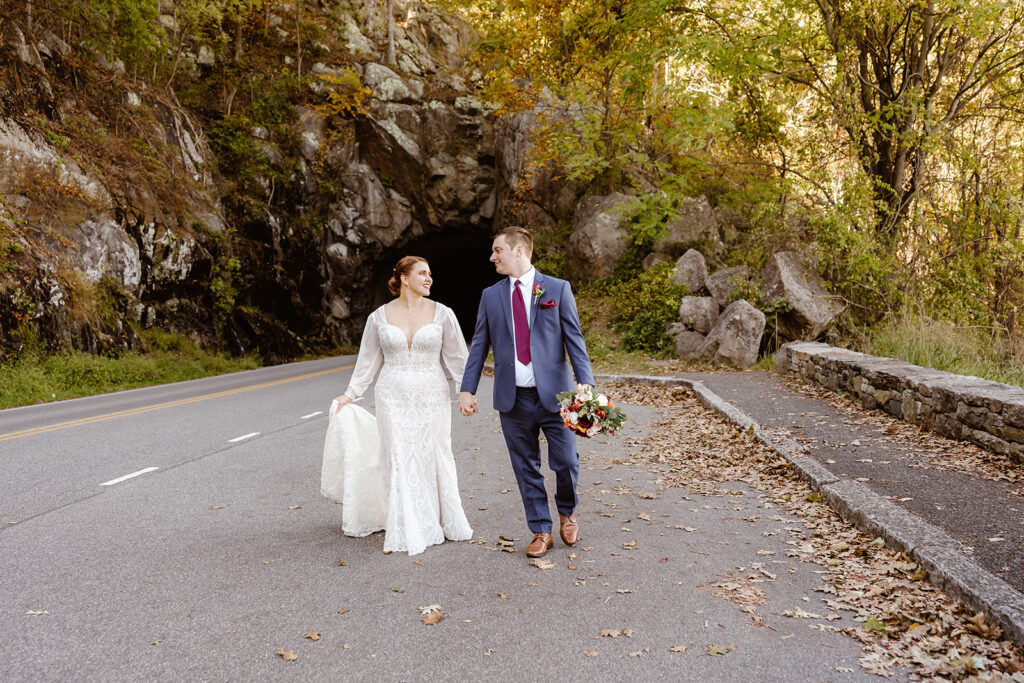 the wedding couple walking along the road at Shenandoah National Park