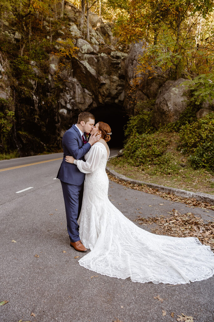 the wedding couple kissing on the road at Shenandoah National Park