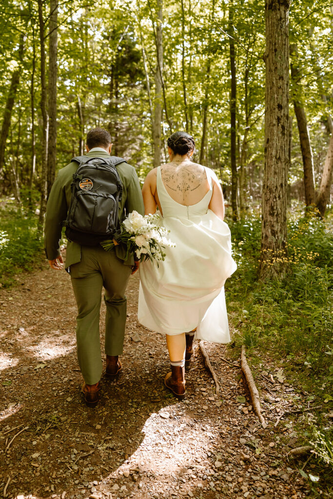 the wedding couple hiking up the mountain together