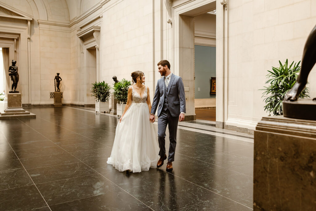 the wedding couple walking through the National Gallery of Art