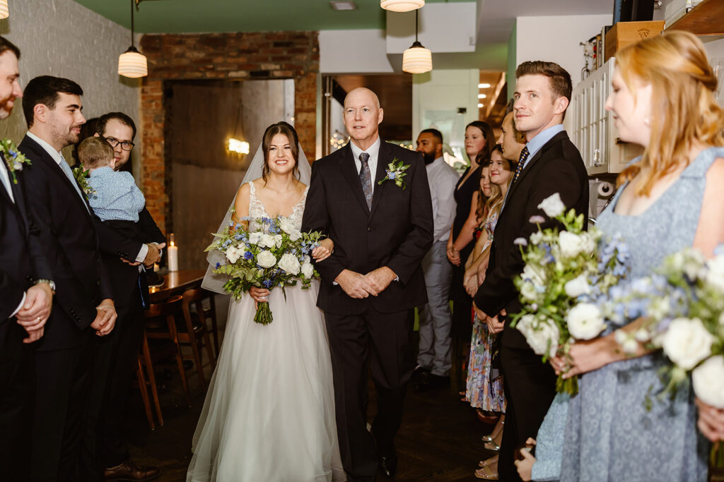 the bride walking down the aisle with her dad