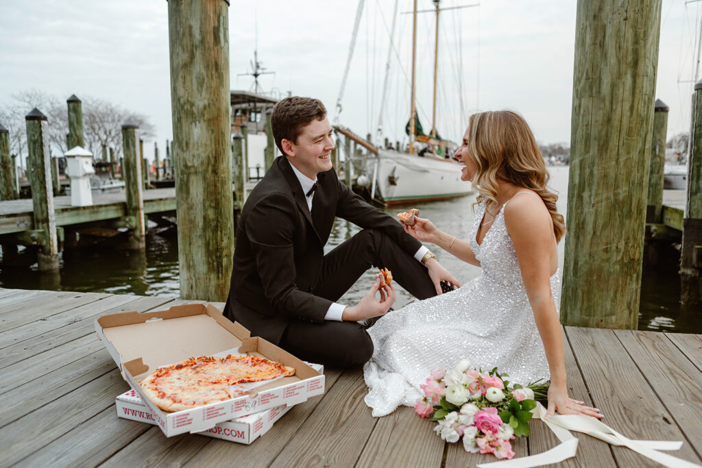 elopement couple eating pizza at the docks in downtown annapolis