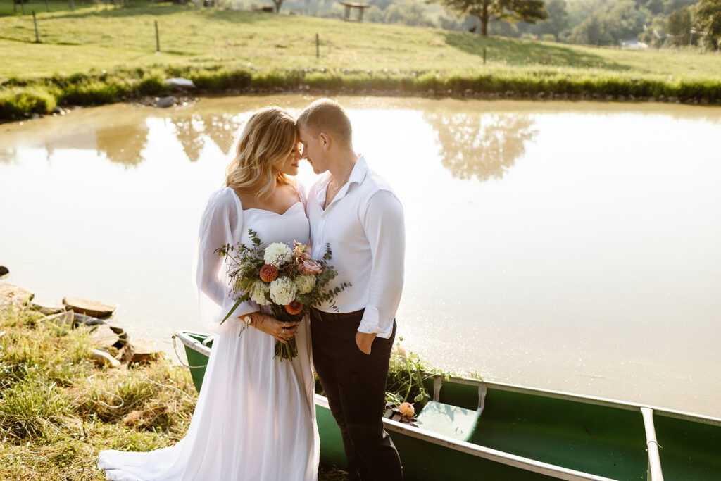 elopement couple posing next to a rowboat