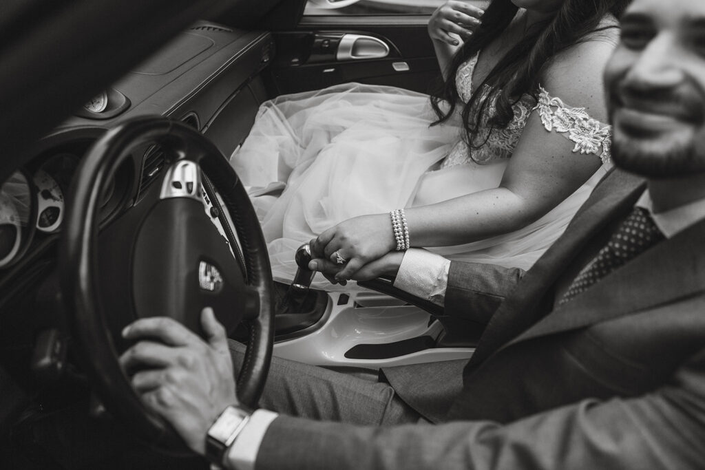 wedding couple holding hands in a car