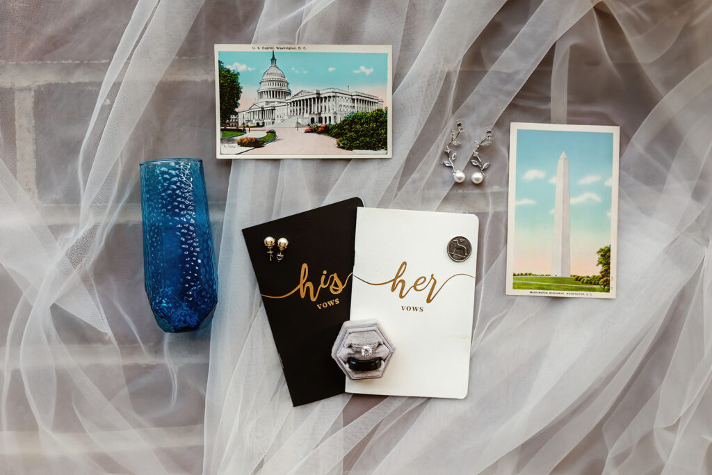 wedding detail flatlay of rings, napkins and vow books