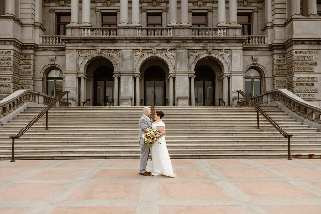 bride and groom exploring the area of library of congress in dc during their cherry blossom wedding elopement