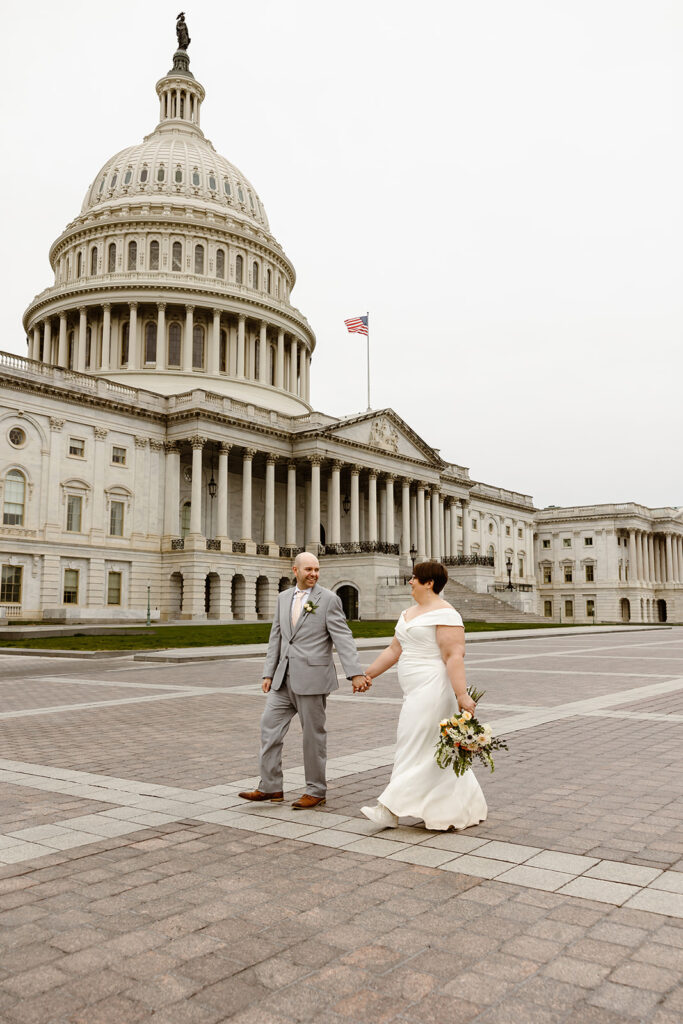 bride and groom exploring the area of library of congress in dc during their cherry blossom wedding elopement