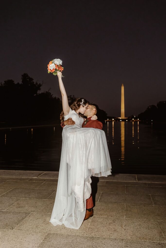 elopement couple kissing during the nighttime in washington dc with the national mall in the backdrop