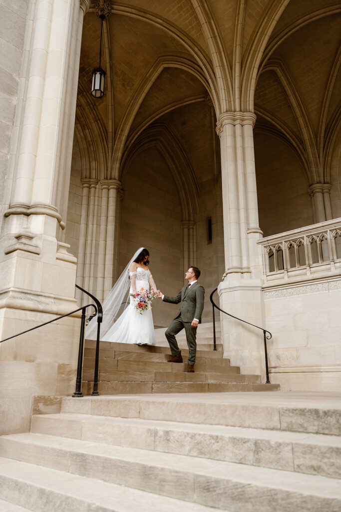 the wedding couple walking together outside of the national cathedral in Washington DC