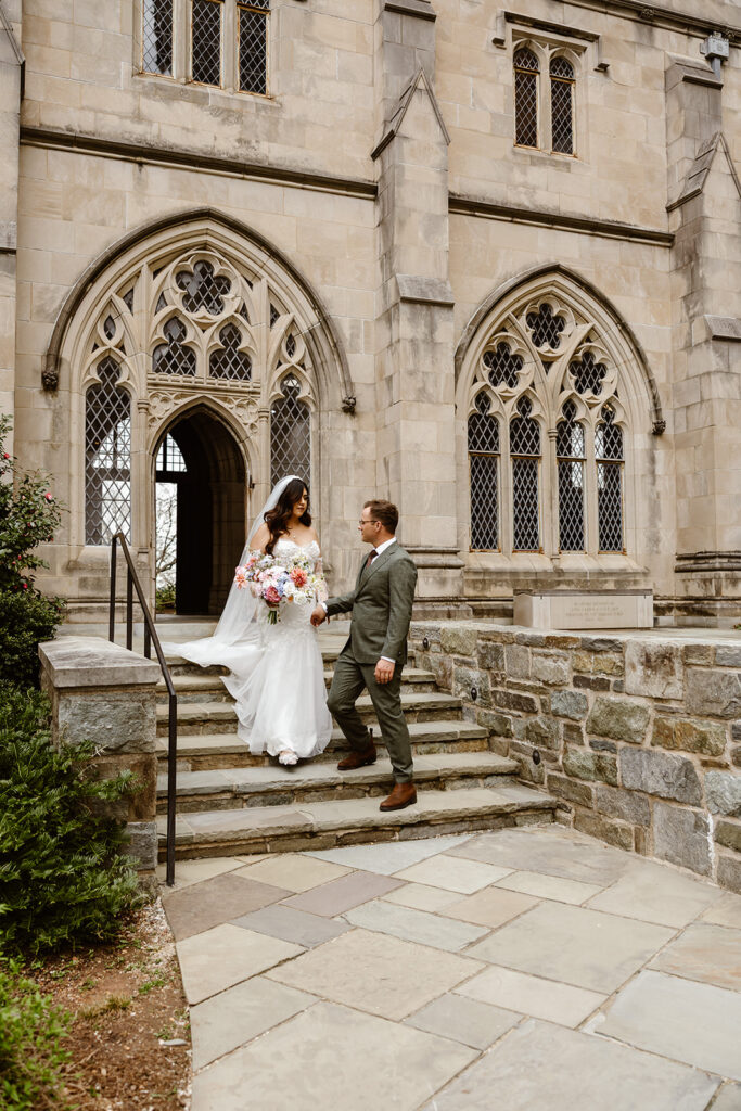 the wedding couple walking together outside of the national cathedral in Washington DC