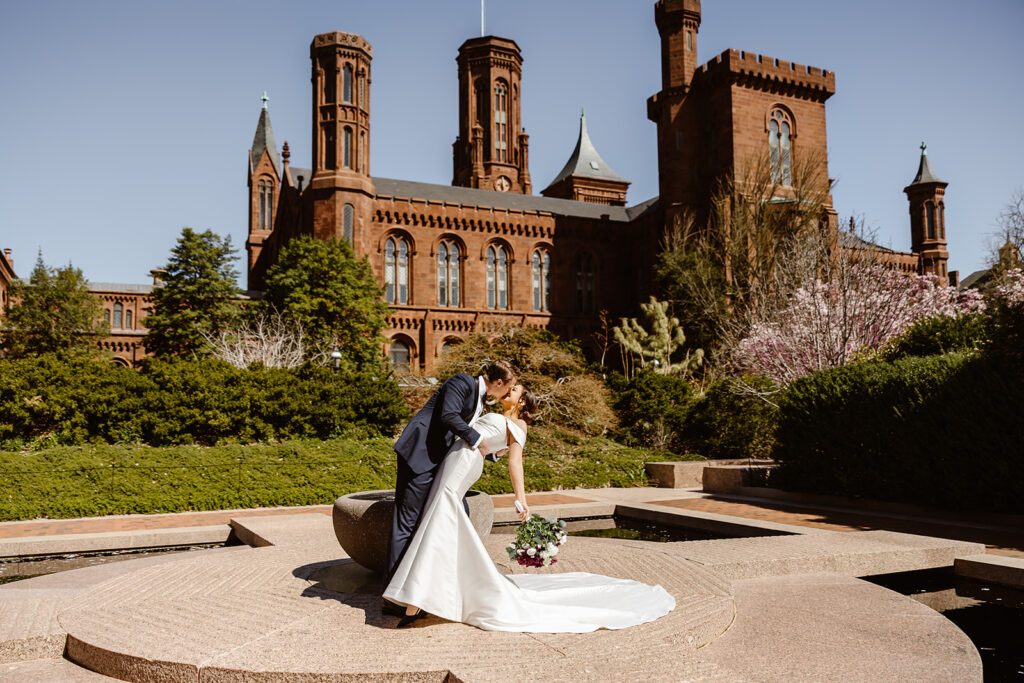 elopement couple dip kiss in front of the smithsonian castle