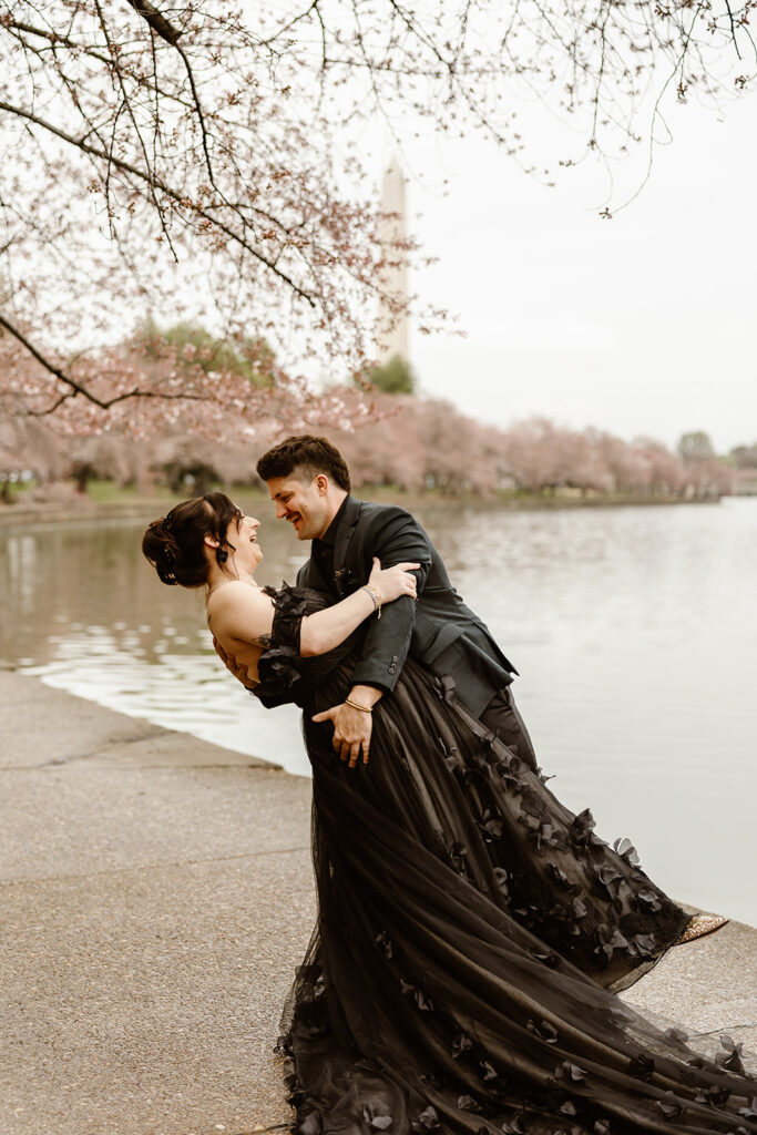 elopement couple with cherry blossoms in the backdrop as they elope in washington dc