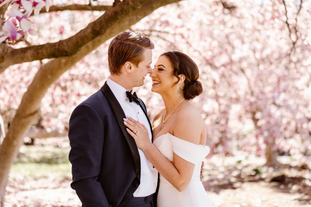 bride and groom surrounded by pink blossoms during their dc micro wedding