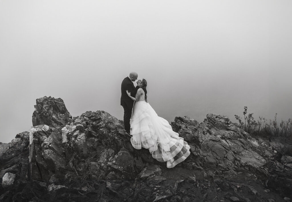 bride and groom kissing on a foggy overlook in shenandoah