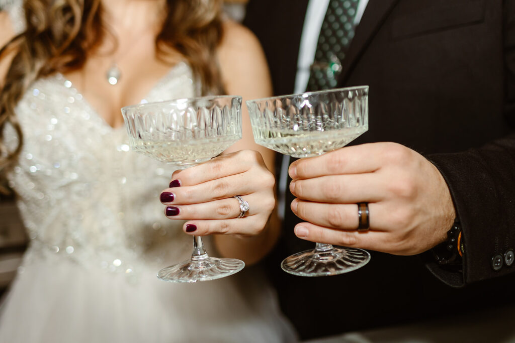 close up of bride and groom holding stunning vintage champagne glasses