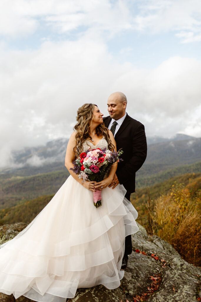 bride and groom posing on foggy overlook at Stony Man summit in Shenandoah during their Shenandoah National Park elopement in October