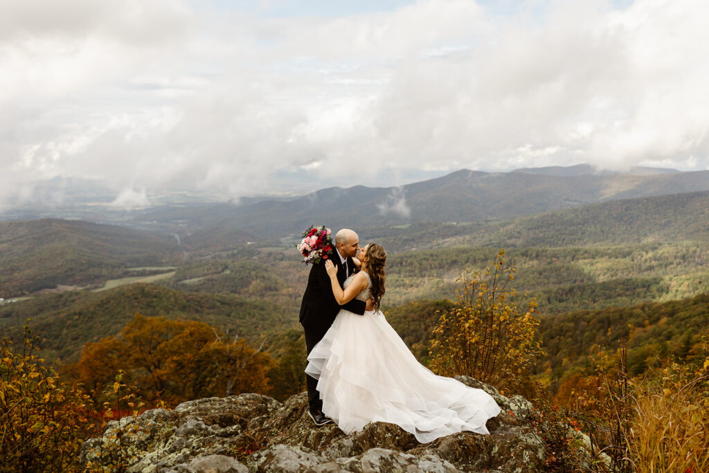 bride and groom kissing on foggy overlook at Stony Man summit in Shenandoah during their Shenandoah National Park elopement in October