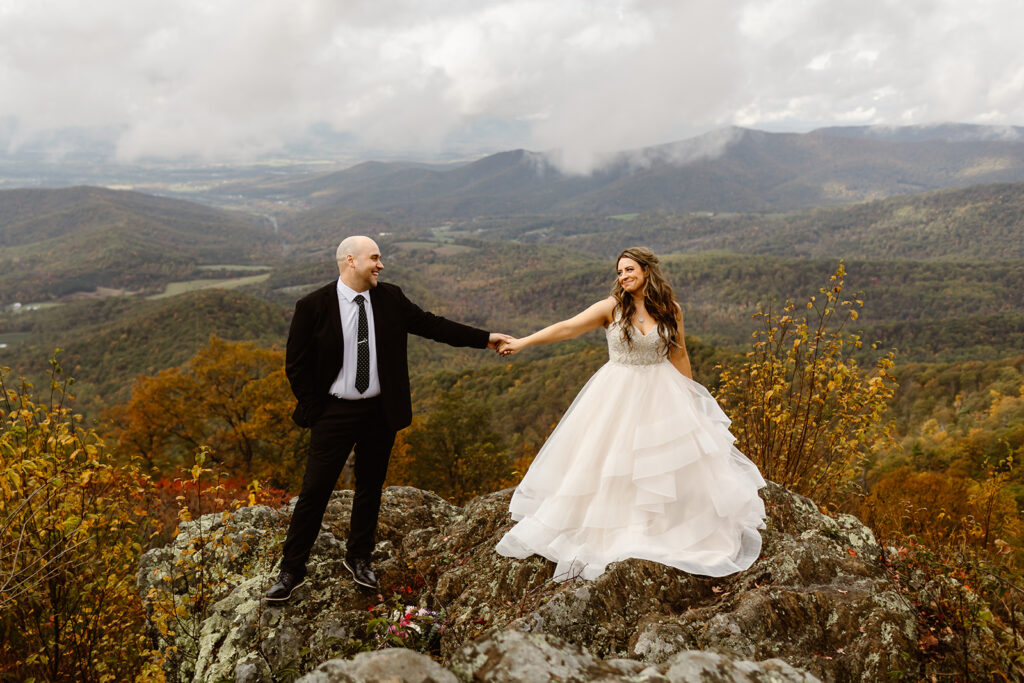 bride and groom posing on foggy overlook at Stony Man summit in Shenandoah during their Shenandoah National Park elopement in October