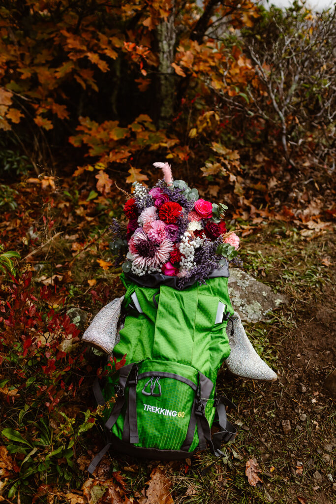 elopement backpack set on a trail surrounded by fall foliage