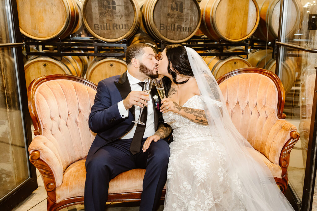 bride and groom toasting champagne in the barrel room at the winery at bull run