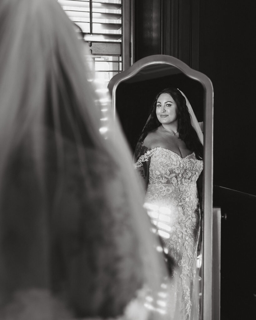 bride captured as she is looking in the mirror