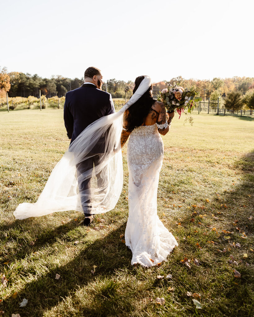 bride and groom walking in the vineyards during their winery micro wedding in northern virginia