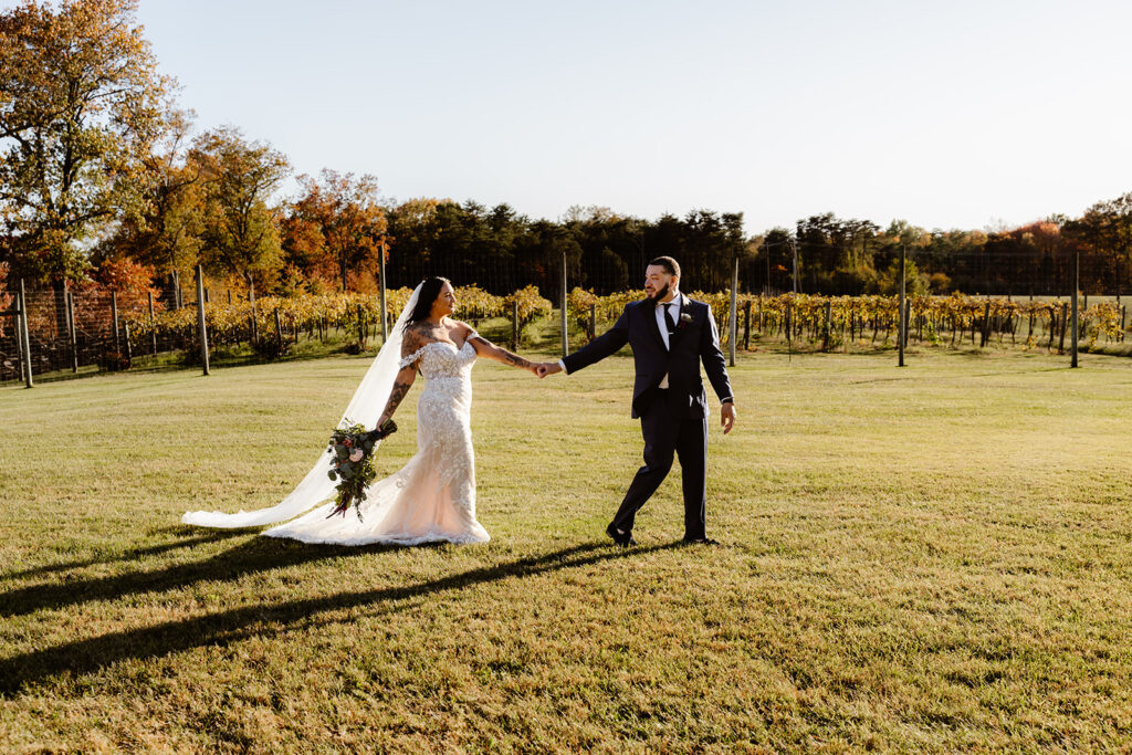 bride and groom walking in the vineyards during their winery micro wedding in northern virginia