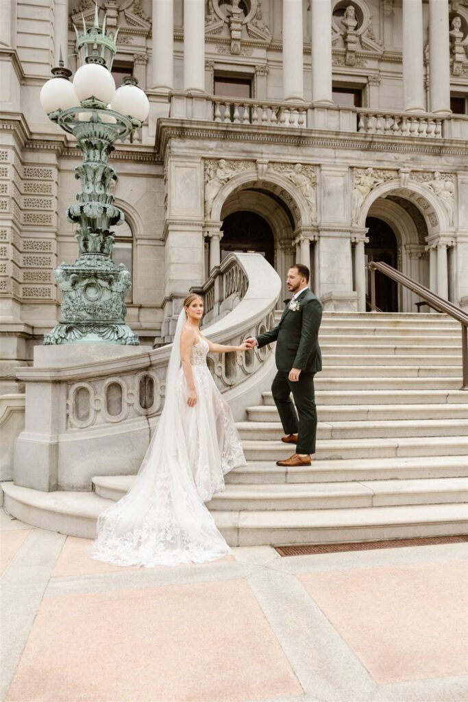 sweet elopement couple holding hands on the stairs in front of the library of congress