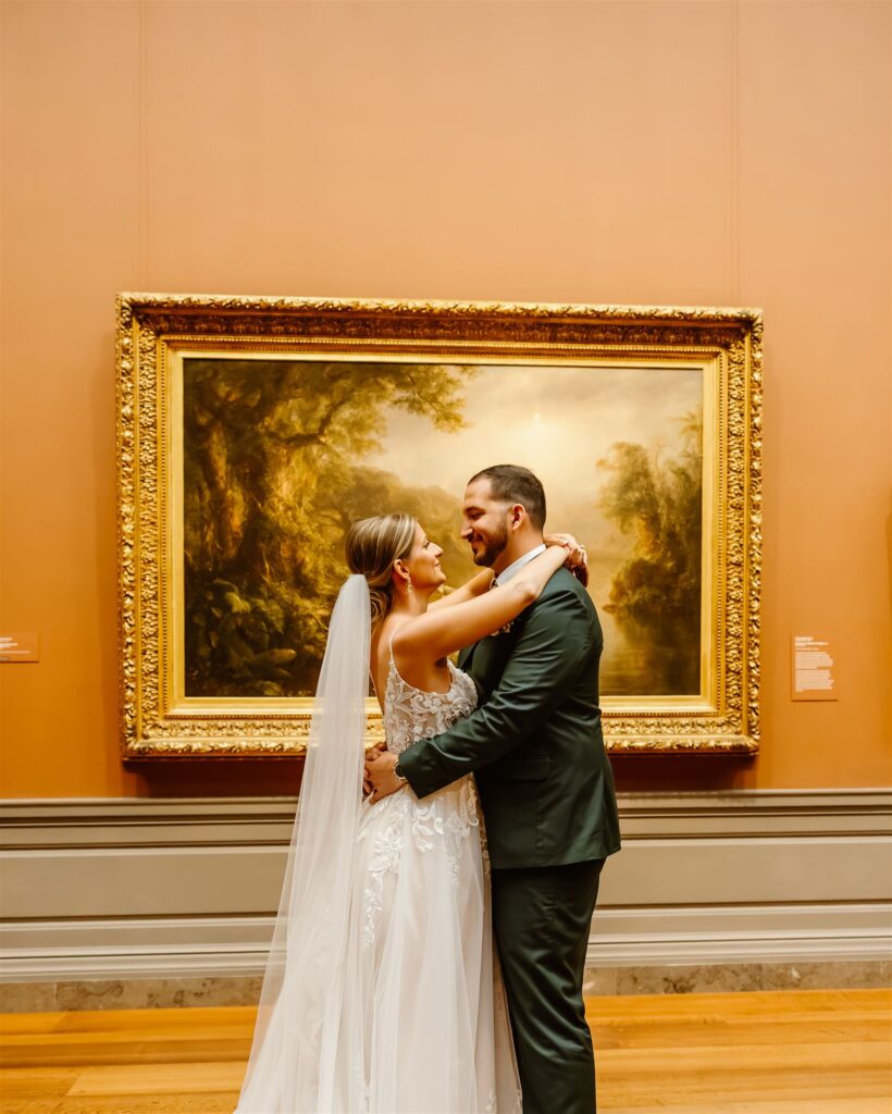 bride and groom kissing in front of paintings at the national gallery of art