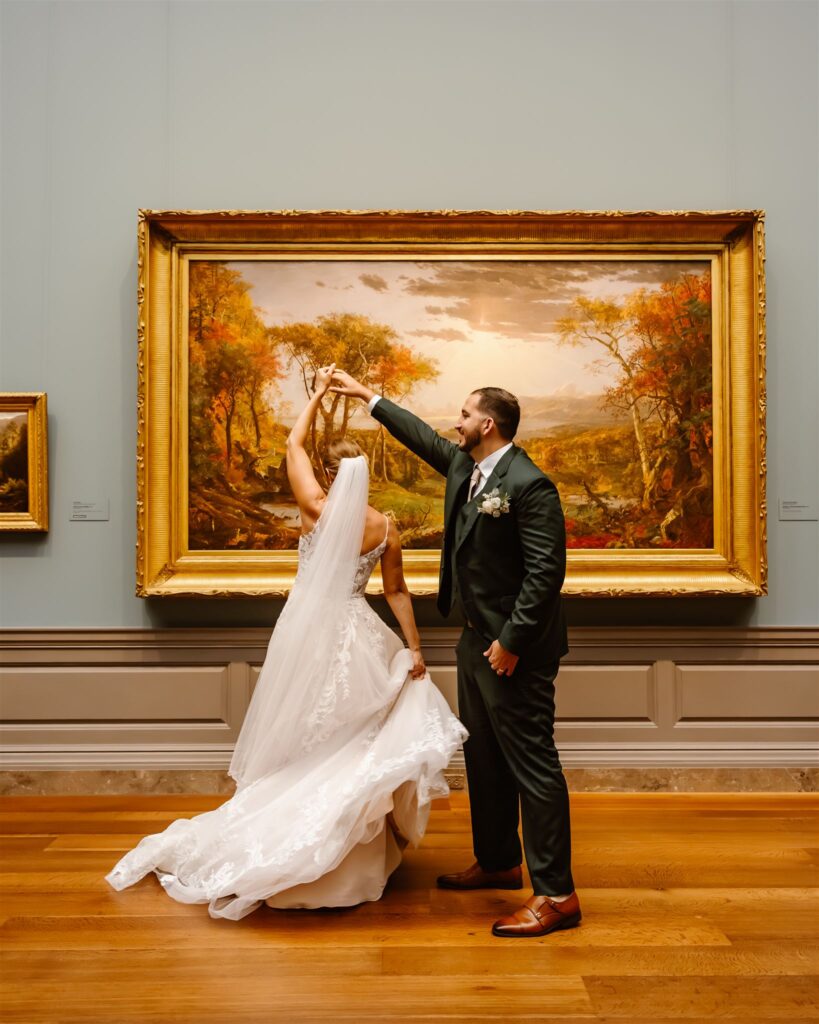 bride and groom dancing in front of paintings at the national gallery of art
