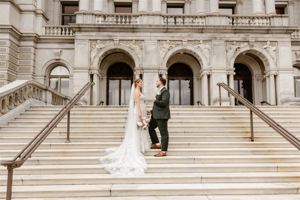 sweet elopement couple holding hands on the stairs in front of the library of congress