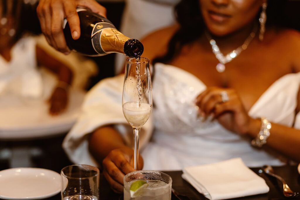 groom pouring his bride some champagne