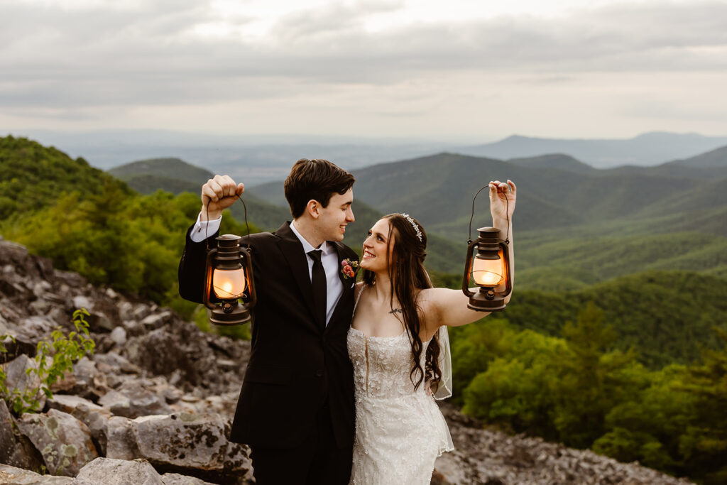 elopement couple with lanterns at a mountain overlook during their summer elopement in shenandoah