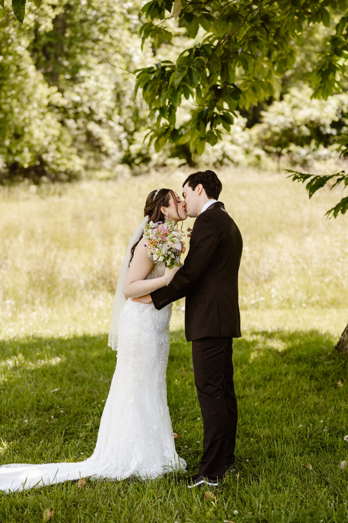 bride and groom elopement first look in a lush green field