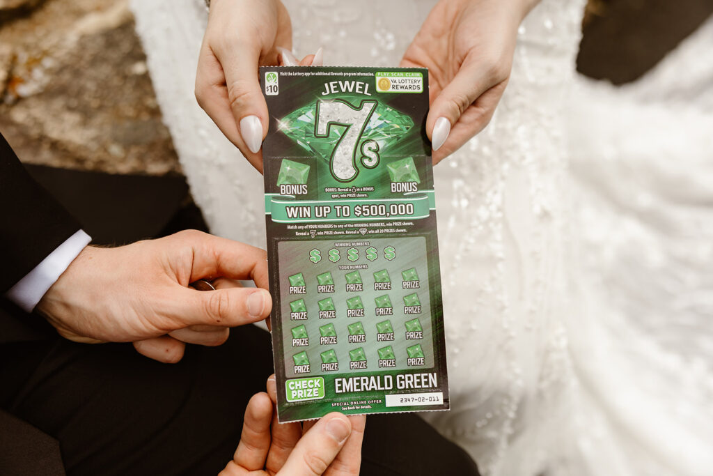 bride and groom scratching off a lottery ticket at a mountain overlook during their shenandoah summer elopement