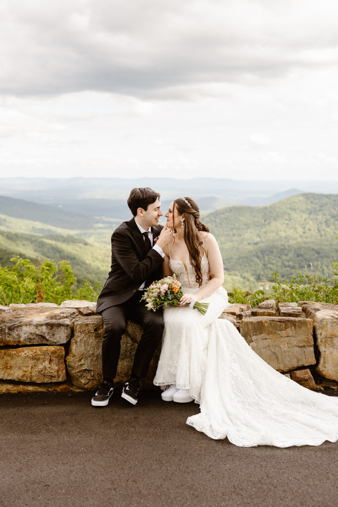 elopement couple kissing at a mountain overlook during their summer elopement in shenandoah