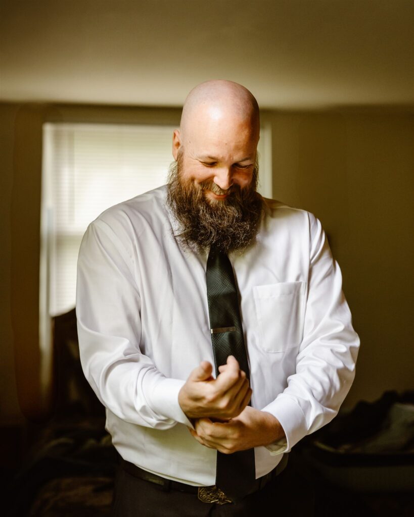 groom putting finishing touches to his elopement look