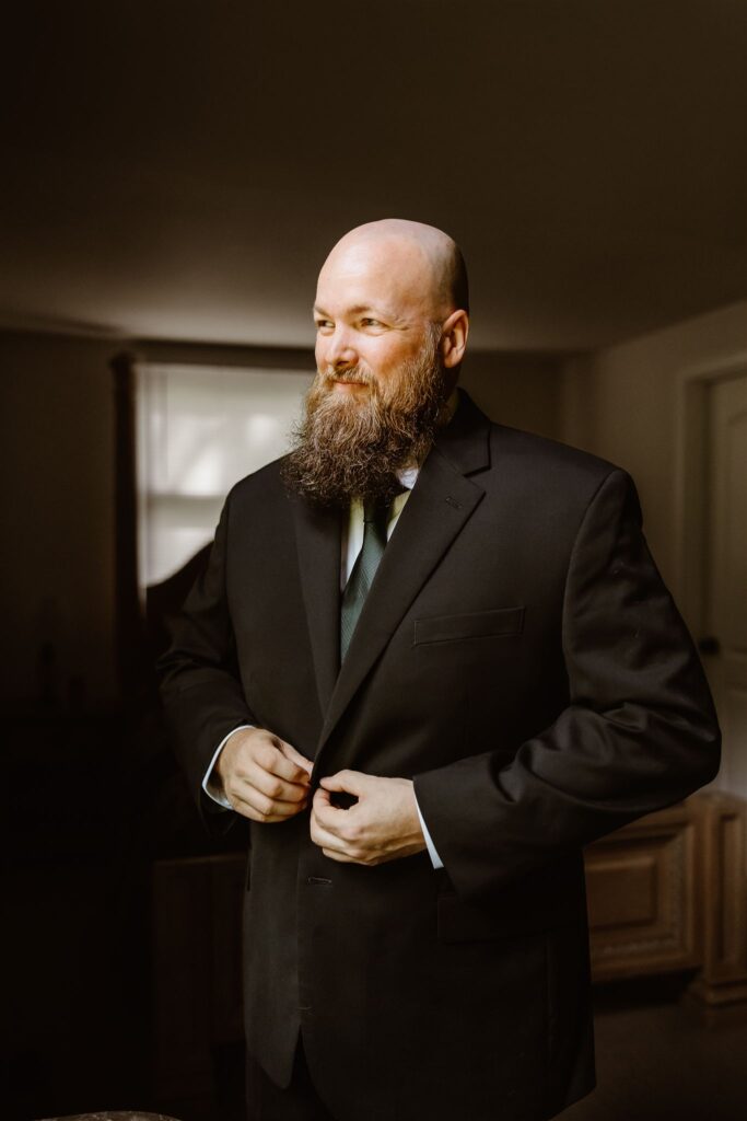 groom putting finishing touches to his elopement look