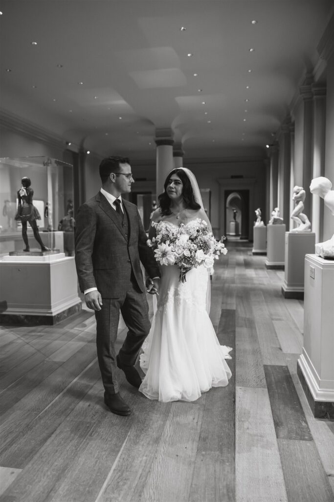 bride and groom walking hand in hand at the national gallery of art