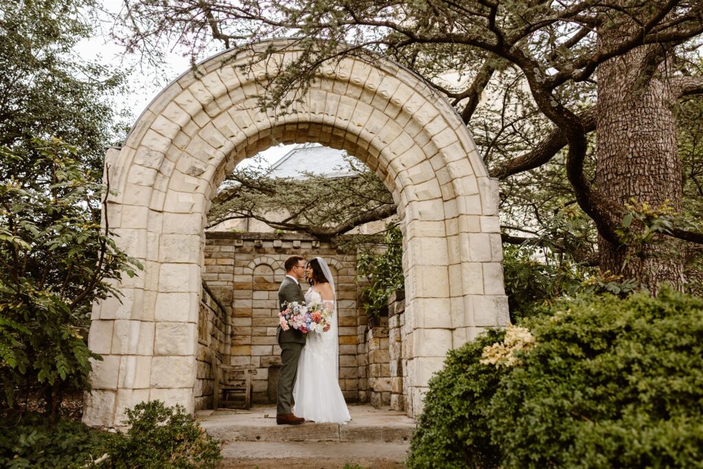 bride and groom exploring the national cathedral gardens during their dc cherry blossom wedding day