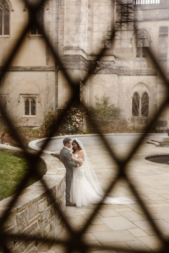 bride and groom exploring the national cathedral grounds during their dc cherry blossom wedding day