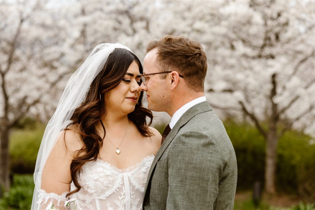 romantic bride and groom exploring tidal basin during their dc cherry blossom wedding 