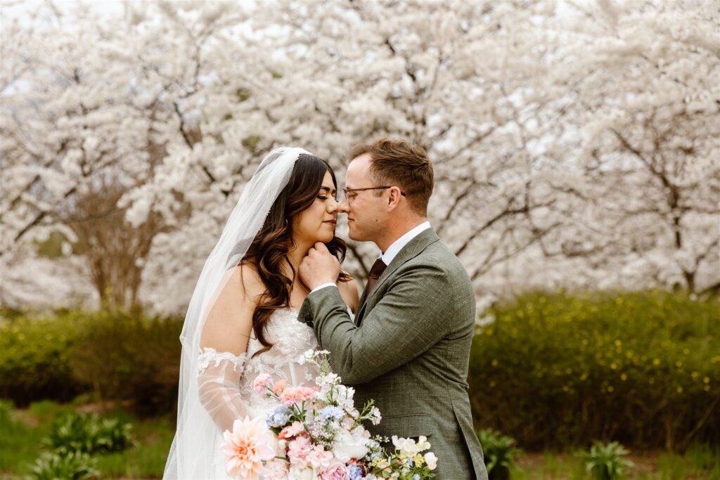 romantic bride and groom exploring tidal basin during their dc cherry blossom wedding 
