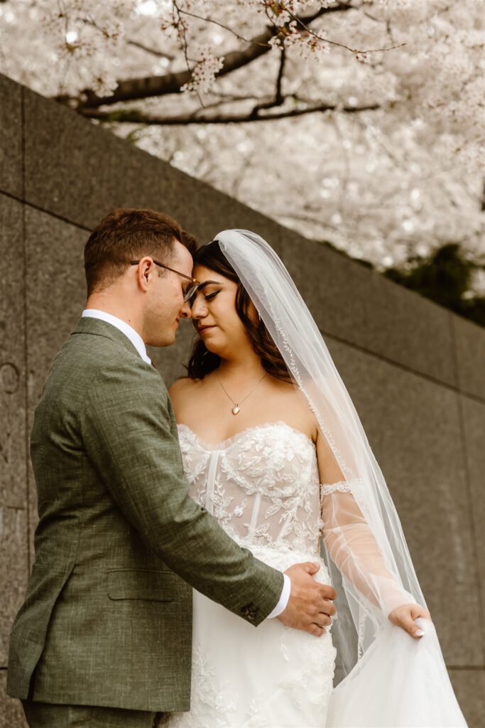romantic bride and groom exploring tidal basin during their dc cherry blossom wedding 