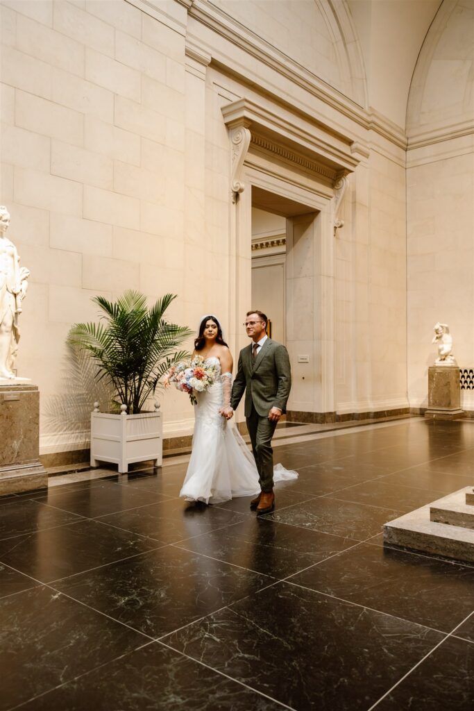 bride and groom walking hand in hand at the national gallery of art