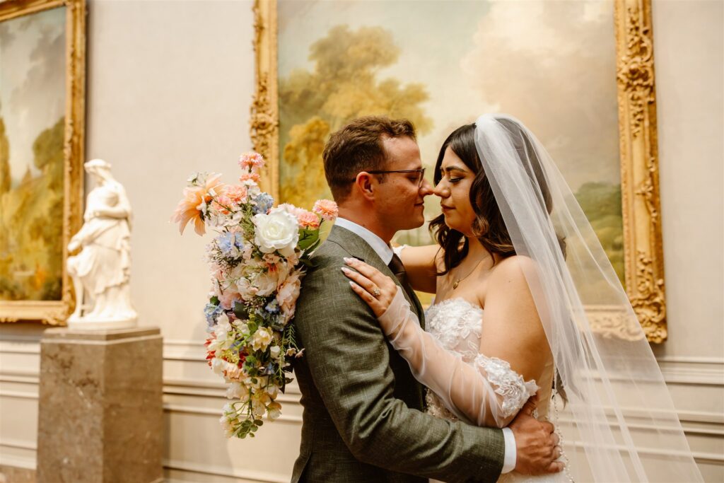 bride and groom cuddling in front of the gorgeous artwork at the national gallery of art