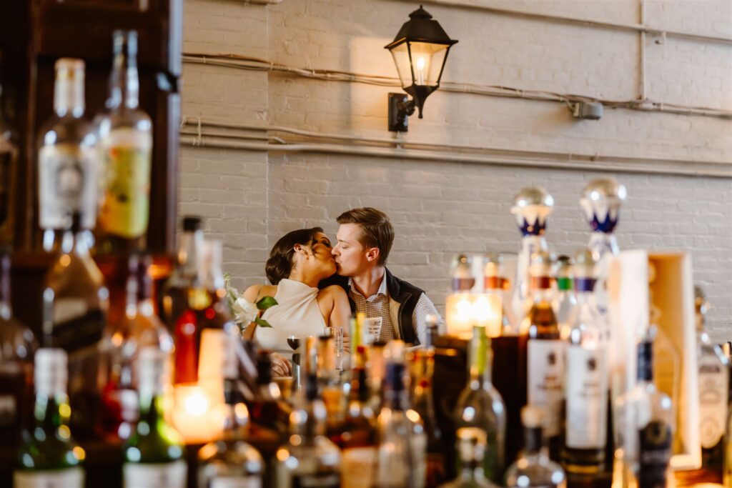 bride and groom sitting at a cocktail bar together