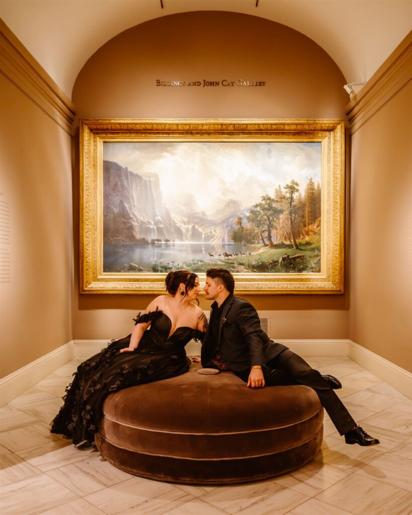 bride and groom sitting in front of a painting at the national portrait gallery 